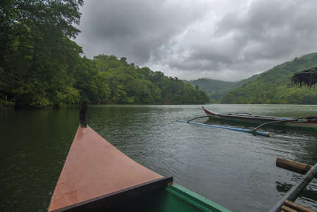 Boats parked on the shore of a tropical green lake, Philippines.