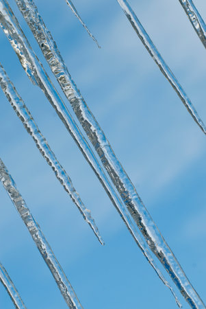 Icicles against the blue sky, close-up, horizontal.