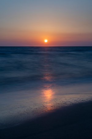 Long exposure by the sea. Waves break against stones. Sunset at the beach. Long exposure at night by the sea. Patara Beach Antalya Turkeyの写真素材