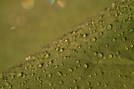 Water droplets on waterproof fabric.Water drops on a green waterproof fabric close-up macro photography.Water drops on a waterproof fabric.の写真素材