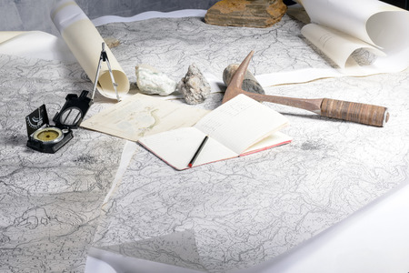 The geological expedition is prepared with the study of topographic maps  On the table the tools of the geologist の写真素材