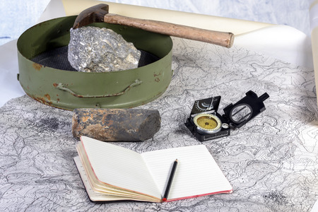 The geological expedition is prepared with the study of topographic maps  On the table the tools of the geologist の写真素材