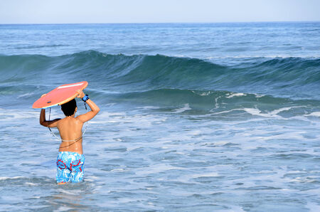 Happy summer for the child at the beach with the waves and splashing water.