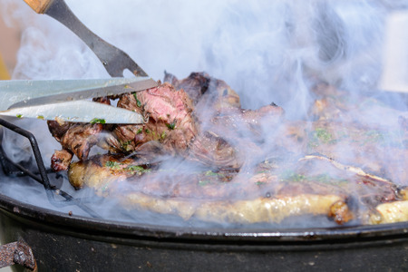 Roast beef, cooked in the outdoor barbecue in a rural location. Sauce: olive oil, salt, parsley.の写真素材