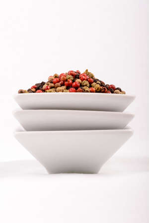 Colorful peppercorns in a white mixing bowl. Horizontal cut with white background.の写真素材