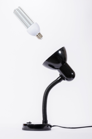 Led lamp on illuminated with black lamp holder. White backgroundの写真素材