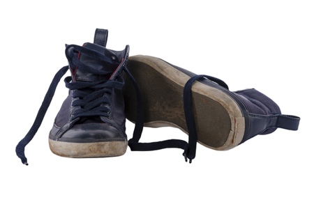 Old worn blue boy shoes isolated on white background.の写真素材