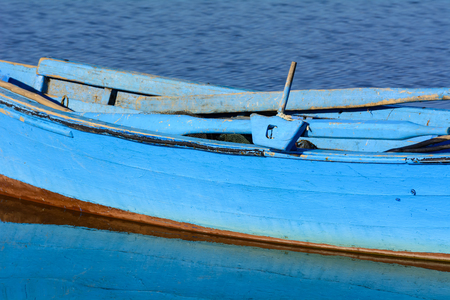 Particular of old wooden fishing boats with bright colors at dawn on the lake. Bright colors: blue, green and yellow.の写真素材
