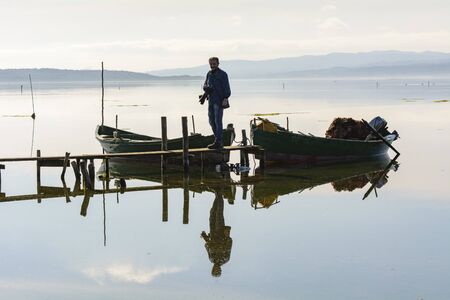 Bruncuteula, Sant'Antioco, Italy - January 28, 2016: Fishermen with their ancient boats, fall at dawn, landscape of the lagoon of Sant'Antioco in south west Sardinia.のeditorial素材