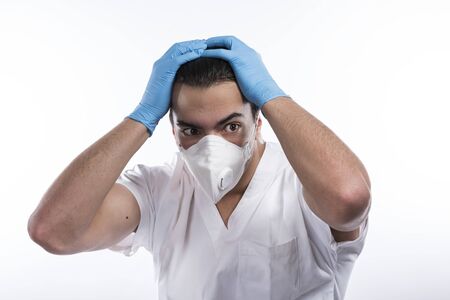 Young male nurse man in blue sterile medical gown face mask gloves isolated on whiteの写真素材