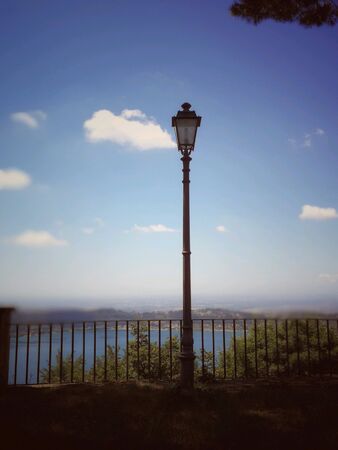 Old lantern on the Nemi Lake outside Rome in a sunny day with clouds spotting on the skyの素材