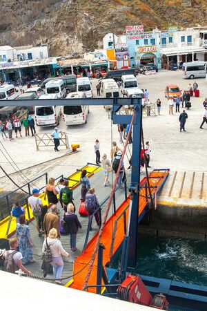 Thira, Greece - 05/20/2015: The Port Of Athinios. Tourists get off the ferry on a missed rampのeditorial素材