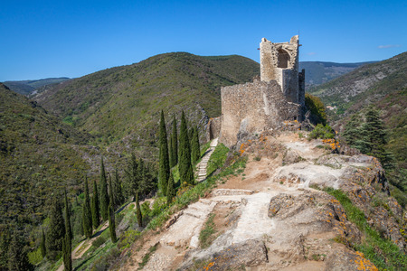 Lastrous castle in France on top of the mountain on a sunny day with trees and pathの写真素材