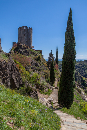 Lastrous castle in France on top of the mountain on a sunny day with trees and pathの写真素材