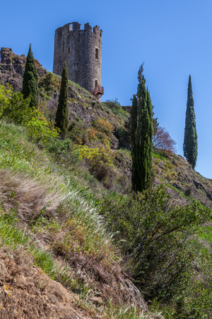 Lastrous castle in France on top of the mountain on a sunny day with trees and pathの写真素材