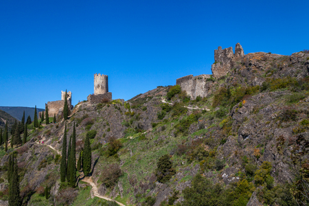 Lastrous castle in France on top of the mountain on a sunny day with trees and pathの写真素材