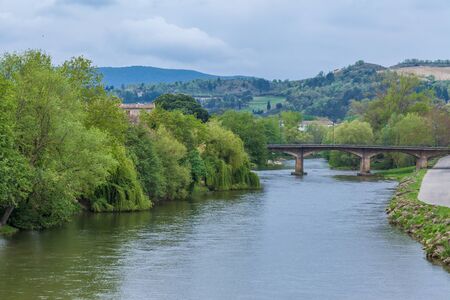 a view of Aude river in Carcassonne with bridge and trees and mountains in the backgroundの写真素材