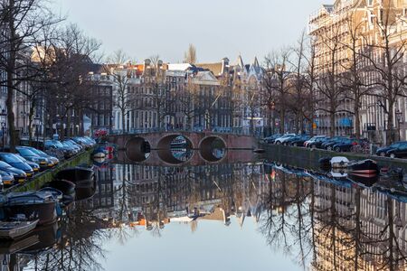 water canals in Amsterdam with a bridge in the middle and traditional architectureのeditorial素材