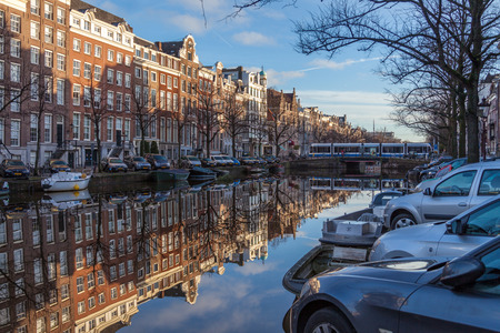 water canals in Amsterdam on a sunny day with traditional architecture reflecting in the waterのeditorial素材