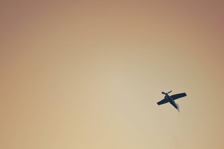 Small wooden toy plane flies in the sky, creative background