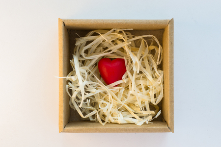 Little wooden red heart in cardboard boxの写真素材