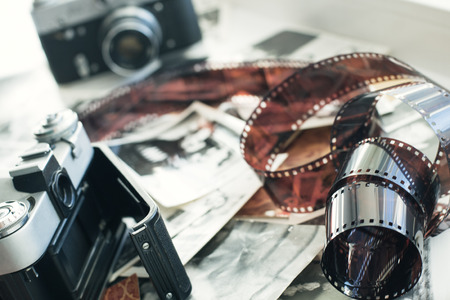Old camera lies in photos next of photographic filmの写真素材