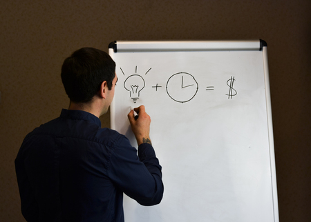 Executive man writing on a flipchart, business presentationの写真素材