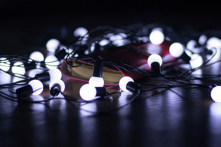 Little white lights on a garland lying on the floor, blur, creative background