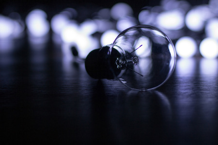 Lamp closeup and little white lights on a garland lying on the floor, blurの写真素材
