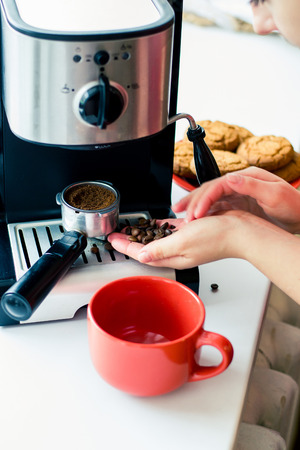 Girl make fresh coffee in a coffee machineの写真素材