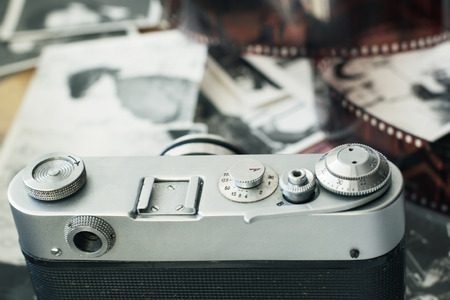 Old camera lies in photos next of photographic filmの写真素材