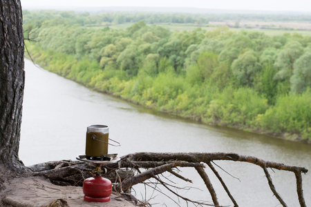 Portable gas burner stay in sand over a cliff above riverの写真素材