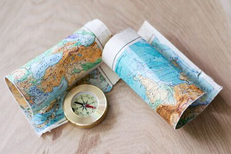 Map and compass lying on wooden background