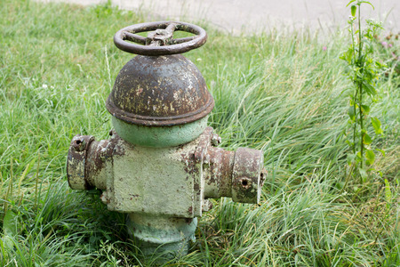 Old hydrant on a background of grassの写真素材