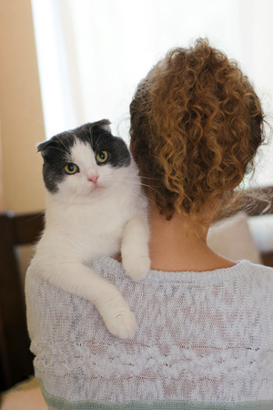 Girl holding a cat on her shoulderの写真素材