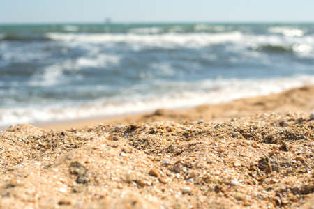 Close-up of sand on the beach and sea waves in the backgroundの写真素材