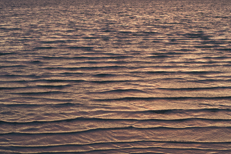 Texture of shallow waves colored by light of the setting sunの写真素材