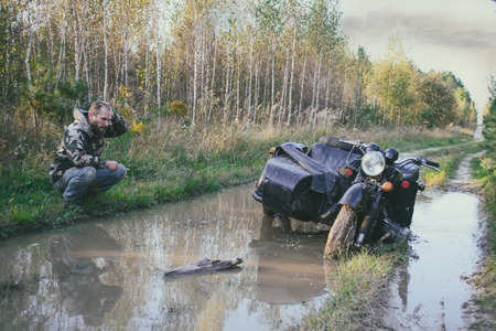 A man riding a motorcycle with a sidecar got stuck on the roadの写真素材