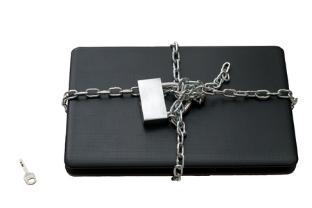 Laptop wrapped in a chain isolated on a white background, computer security themeの写真素材