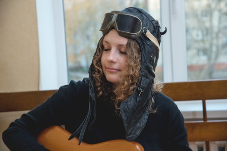 Portrait of a girl playing electric guitar at home, close-up