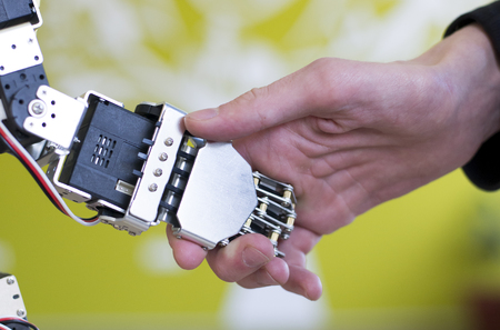 Photo of a human hand holding a robot hand with a handshakeの写真素材