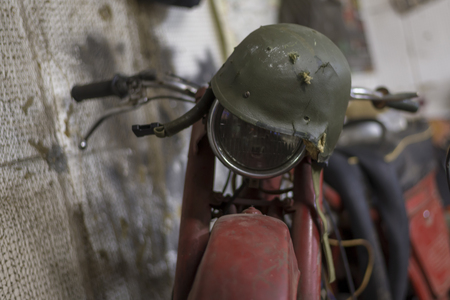 Old broken retro helmet on a vintage motorcycle in the garageの写真素材