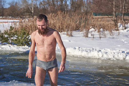 A man after diving into icy water on a Christian winter holidayの写真素材