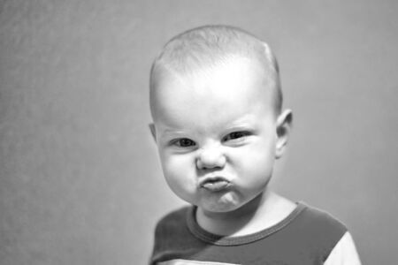 Portrait of a funny boy who grimaces, black and white photo