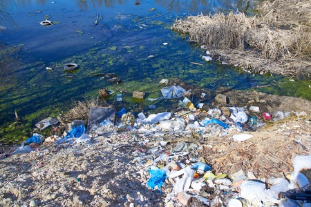 Garbage thrown to the bank of the river, the topic of environmental pollutionの写真素材