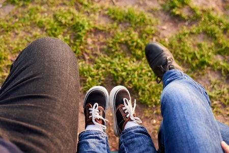 The legs of mom, dad and child on the background of green grass. The family spends time together. Spring Timeの写真素材