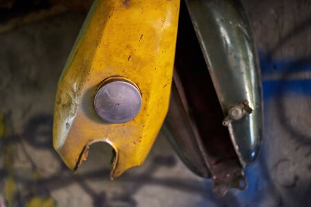 Old tanks of vintage retro motorcycles hang in a garage.の写真素材