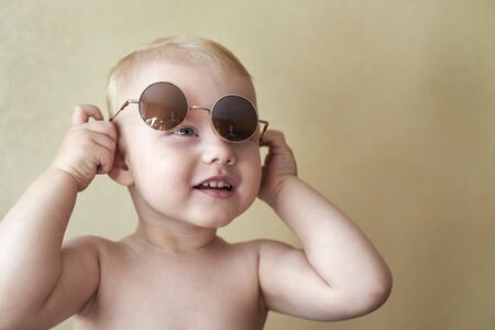 Portrait of a little cute funny boy in a round glasses.の写真素材