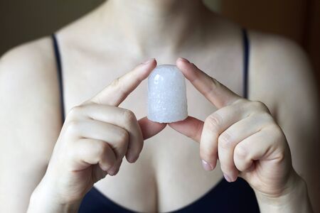 A woman holding a natural deodorant - alunite crystal, natural and therapeutic cosmetics.