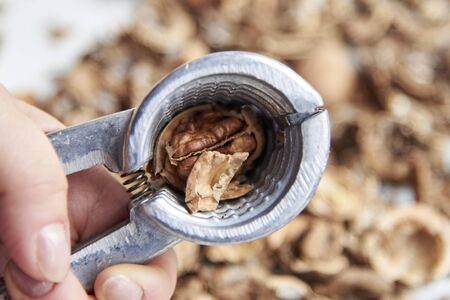 Nutshell with a walnut in the hands of a woman on a background of nuts, the theme of healthy...